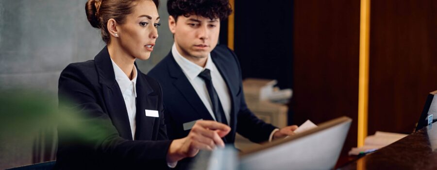 Two hotel managers looking through guest bookings to confirm availability