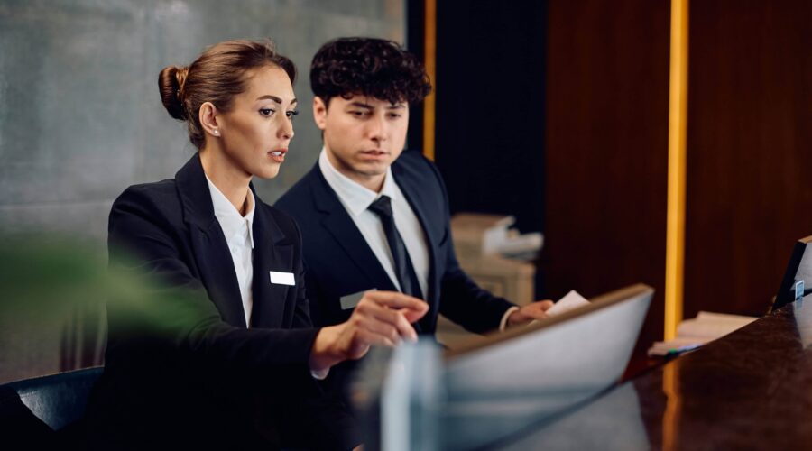 Two hotel managers looking through guest bookings to confirm availability
