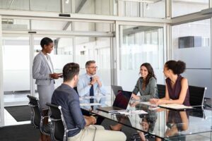 Business colleagues meeting around a table in glass office
