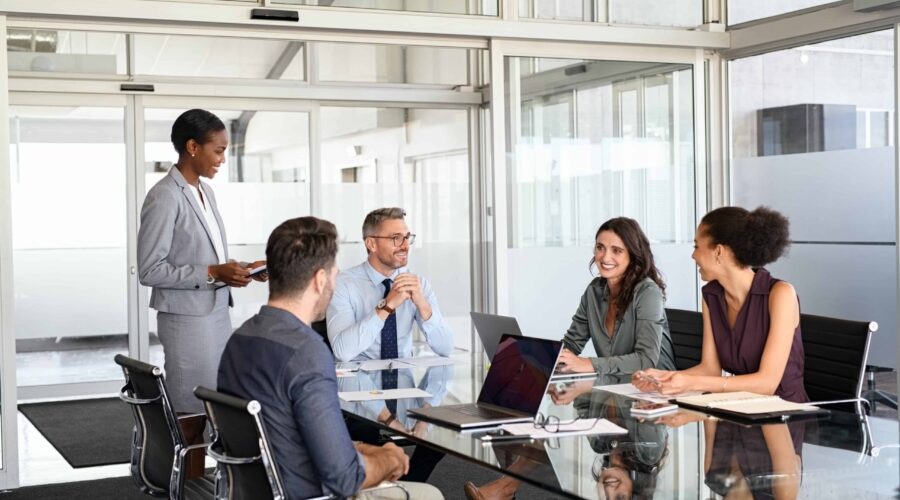Business colleagues meeting around a table in glass office